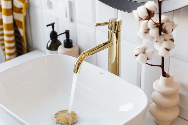 Rubinetto aperto con acqua che scorre.
