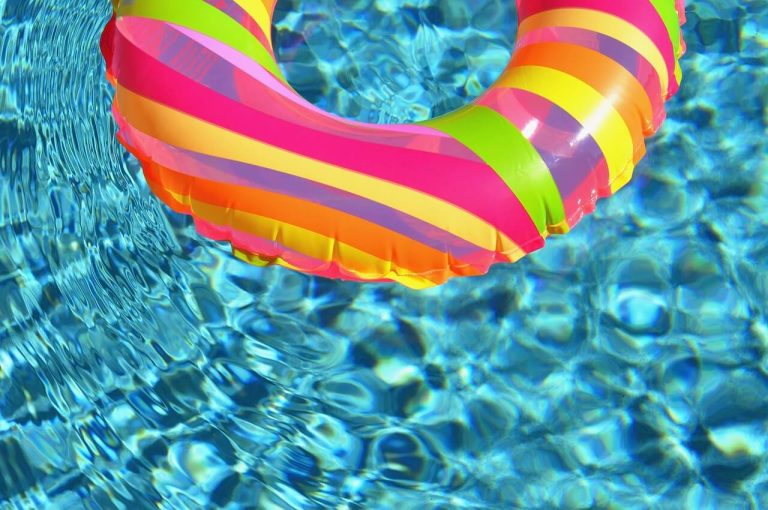 Ciambella gonfiabile colorata che galleggia in una piscina.